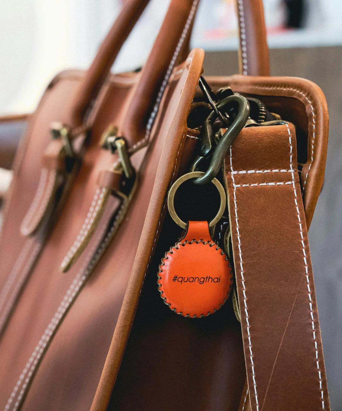 Borsa in pelle con portachiavi accanto a uno smartphone moderno